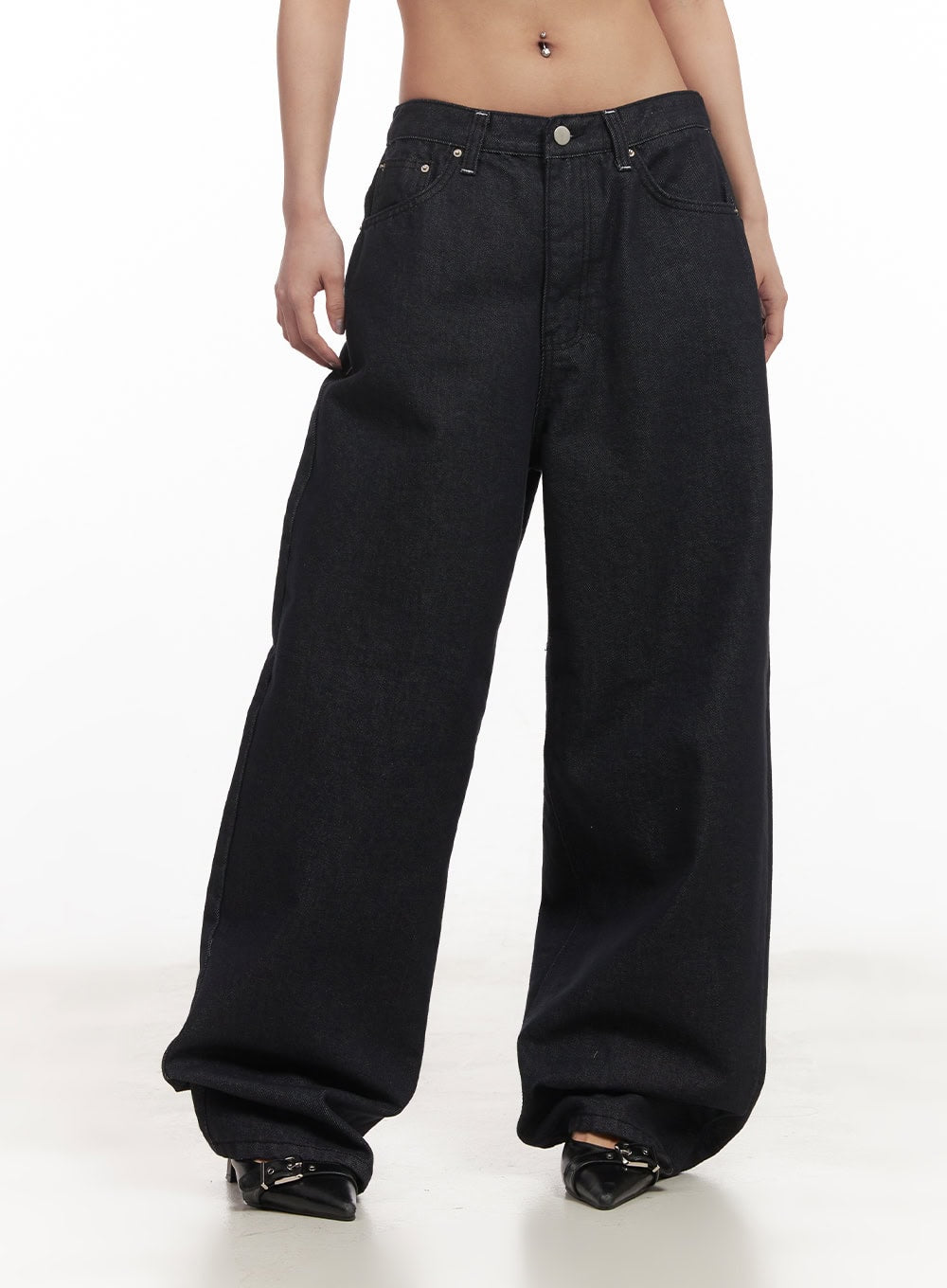 Julianna Baggy Jeans CM505 in black denim, front waist-to-hem shot on model, low-rise fit with silver button closure, wide baggy leg in solid cotton denim, worn with black heels.