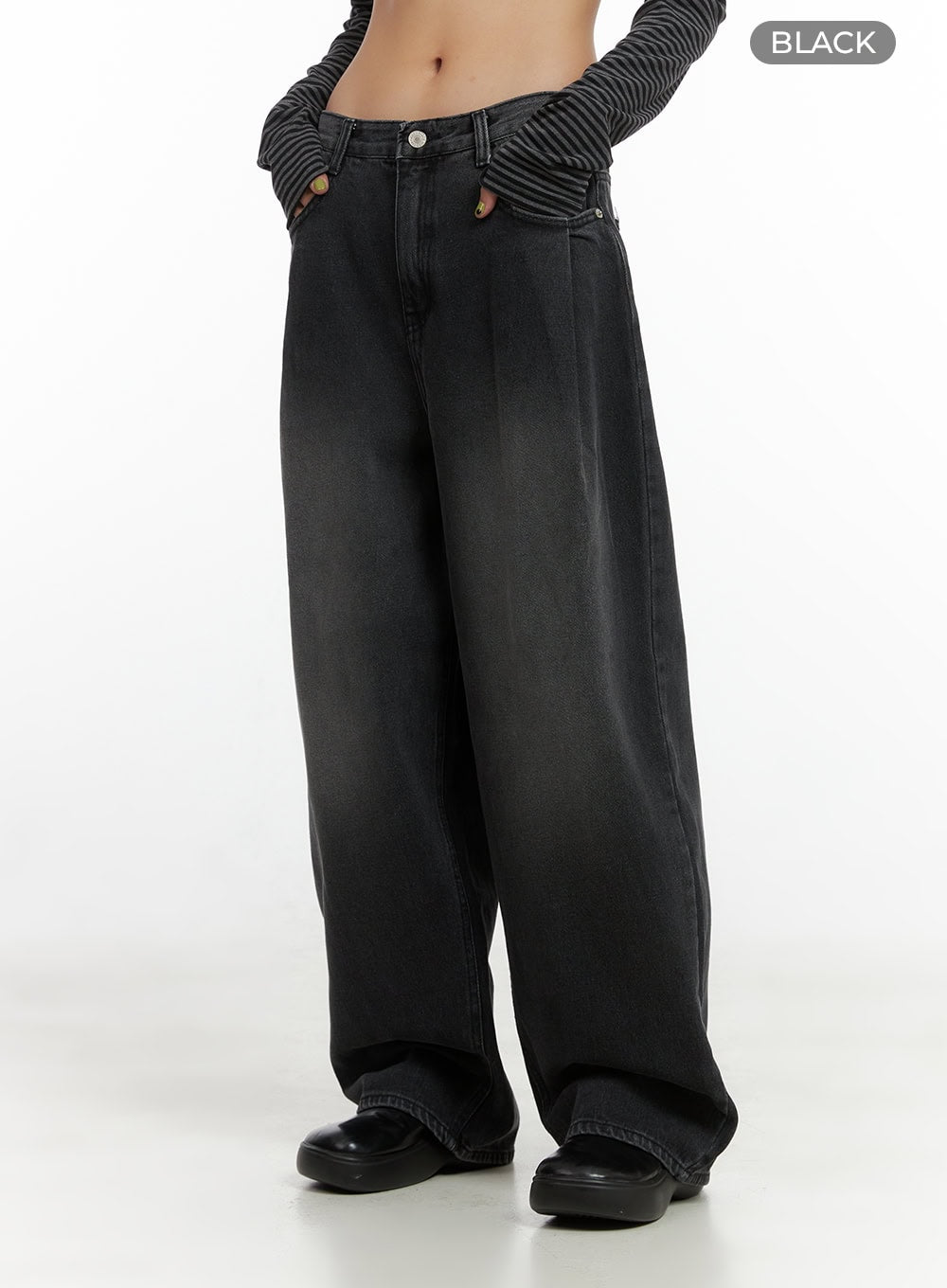 Delilah Pin-Tuck Washed Denim Baggy Jeans CO424 in black, front side close-up from waist down, pintuck crease, gold button hardware, low-rise fit and floor-grazing wide leg on model.