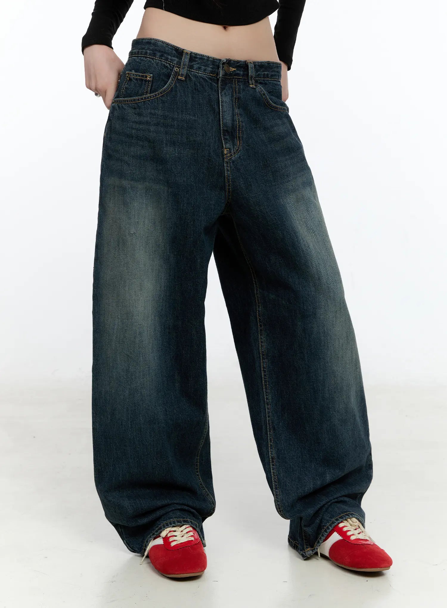 Hunter Washed Wide Leg Jeans CN517 in dark blue, front mid-shot on model with hands in pockets, showing wide-leg sweep and washed fading, paired with black crop top and red sneakers.