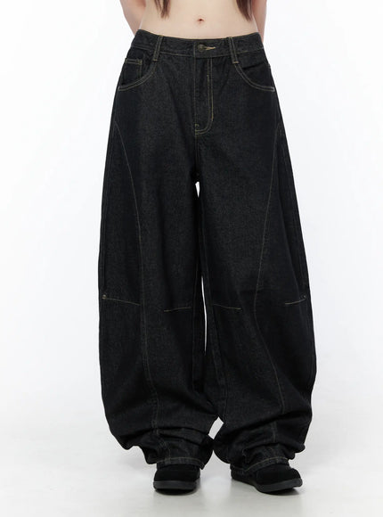 Lova Baggy Jeans CU519 in black, front three-quarter crop view on model, waistband button closure, contrast stitching, and dramatically wide balloon-shaped leg.