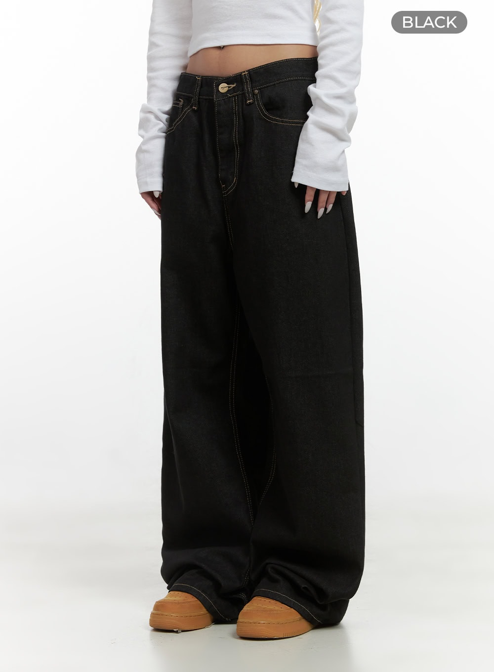 Mara Relaxed Fit Pocketed Cotton Wide Leg Jeans CS426 in black, angled front three-quarter shot on model, low-rise waistband with gold button, contrast stitching, voluminous wide leg hem pooling over sneakers.