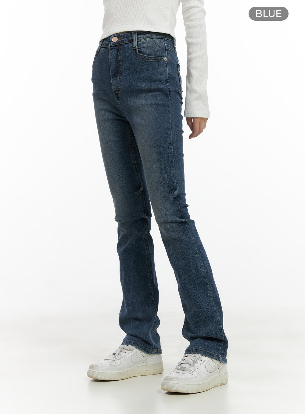 Pixie Slim Washed Bootcut Jeans CG427 in blue, angled side shot from waist down, color-labeled blue, slim high-rise cut with clean washed denim finish and bootcut flare, paired with white sneakers.