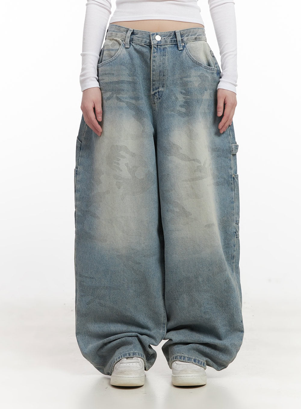 Abigail Camo-Print Carpenter Baggy Jeans CJ528 in blue, front full-length shot on model, arms relaxed, washed camo print clearly visible across wide baggy legs, side carpenter pocket, white sneakers.