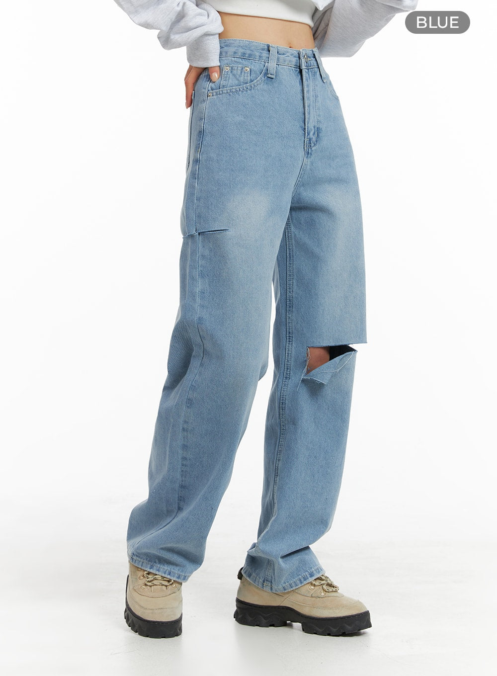 Cut Out Washed Straight Jeans OM421 in blue, front three-quarter view on model, high-rise straight fit with large thigh cut-out, washed fading across leg, paired with white crop top.