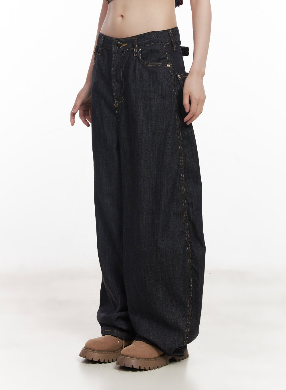 Jessie Stitched Wide-Leg Jeans CY520 in dark blue, side close-up on model from waist to hem, front buckle tab detail, contrast topstitching on low-rise waistband, oversized denim leg.