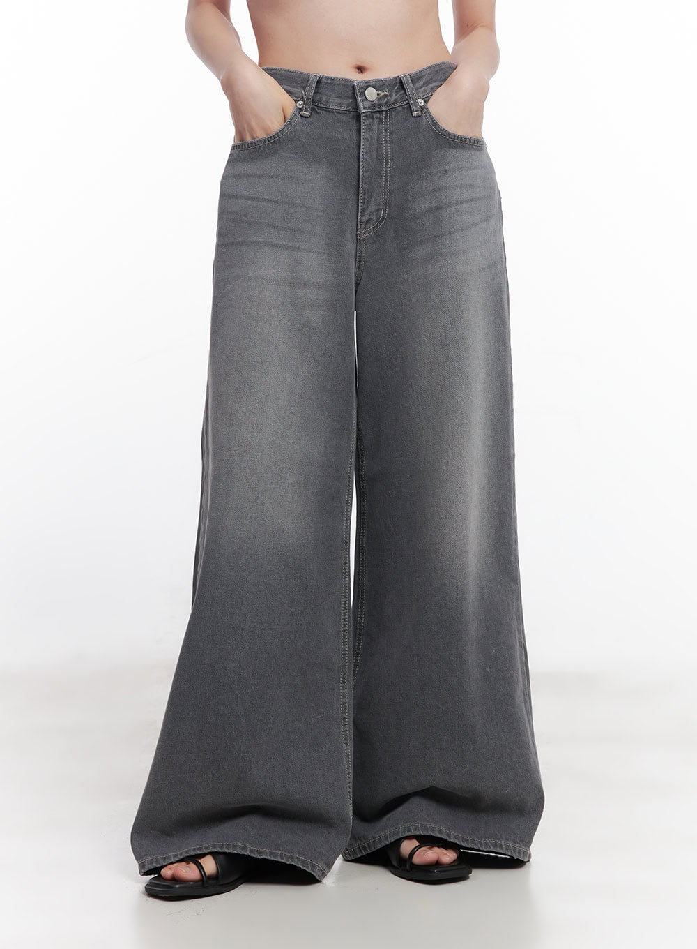 Beatriz Washed Wide-Leg Jeans CY519 in gray, front waist-down close-up on model, hands in pockets, washed gradient denim, exaggerated wide-leg with raw hem, black sandals.