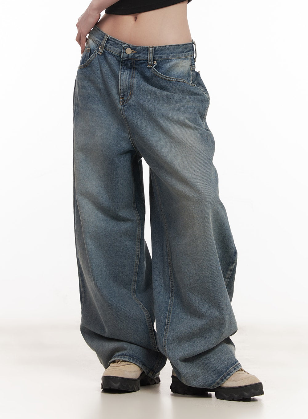 Shelly Washed Baggy Jeans CM518 in blue, front angled close-up on model, low-rise waistband with button fly, washed cotton denim with uneven fading and extra-wide baggy leg.