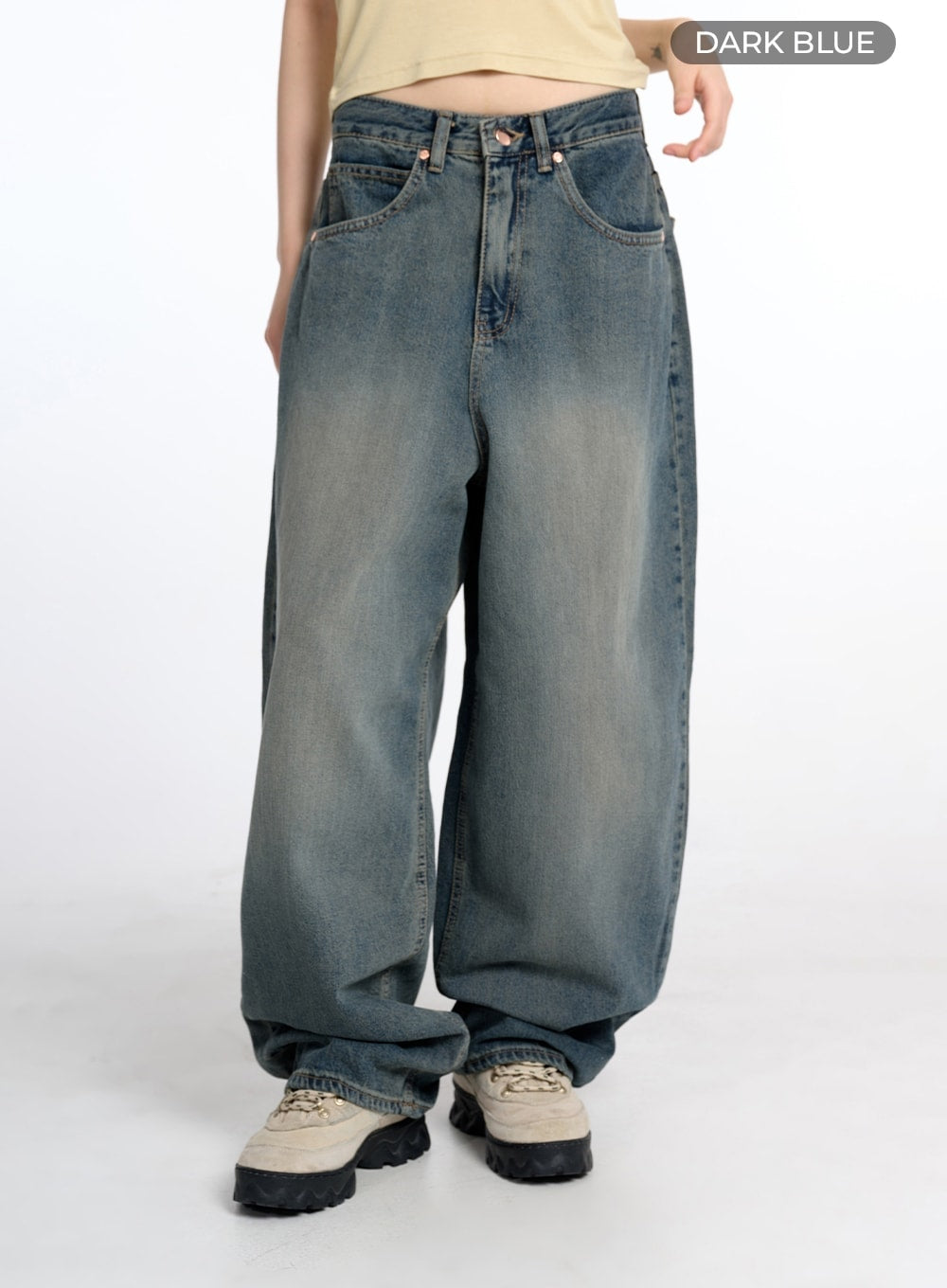 Vintage Low Rise Baggy Jeans CM415 in dark blue, front product shot on model with color label, wide-fit low-rise washed denim with five-pocket styling and voluminous leg, paired with beige crop top.