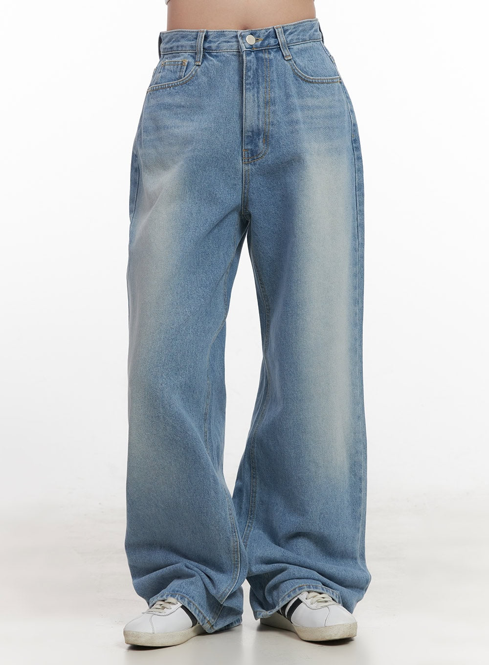 Kelly Washed Baggy Jeans CJ514 in light blue, front mid-shot on model, high-rise waistband with button closure, washed faded denim in relaxed wide fit, styled with white sneakers.
