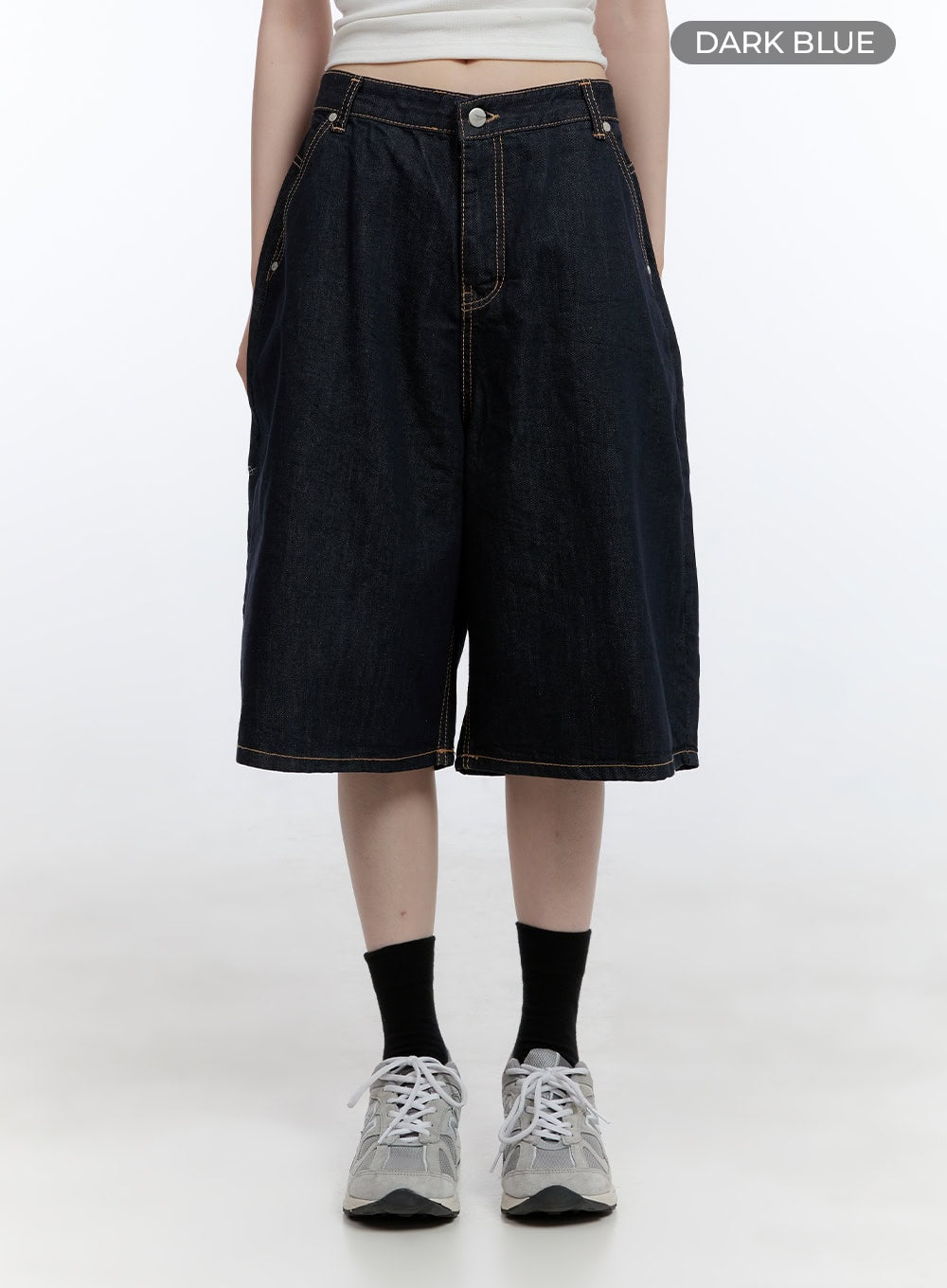 Dora Stitched Baggy Jorts CG413 in dark blue, front product shot on model, wide-fit knee-length denim jorts with contrast topstitching and button fly, color swatch label visible.