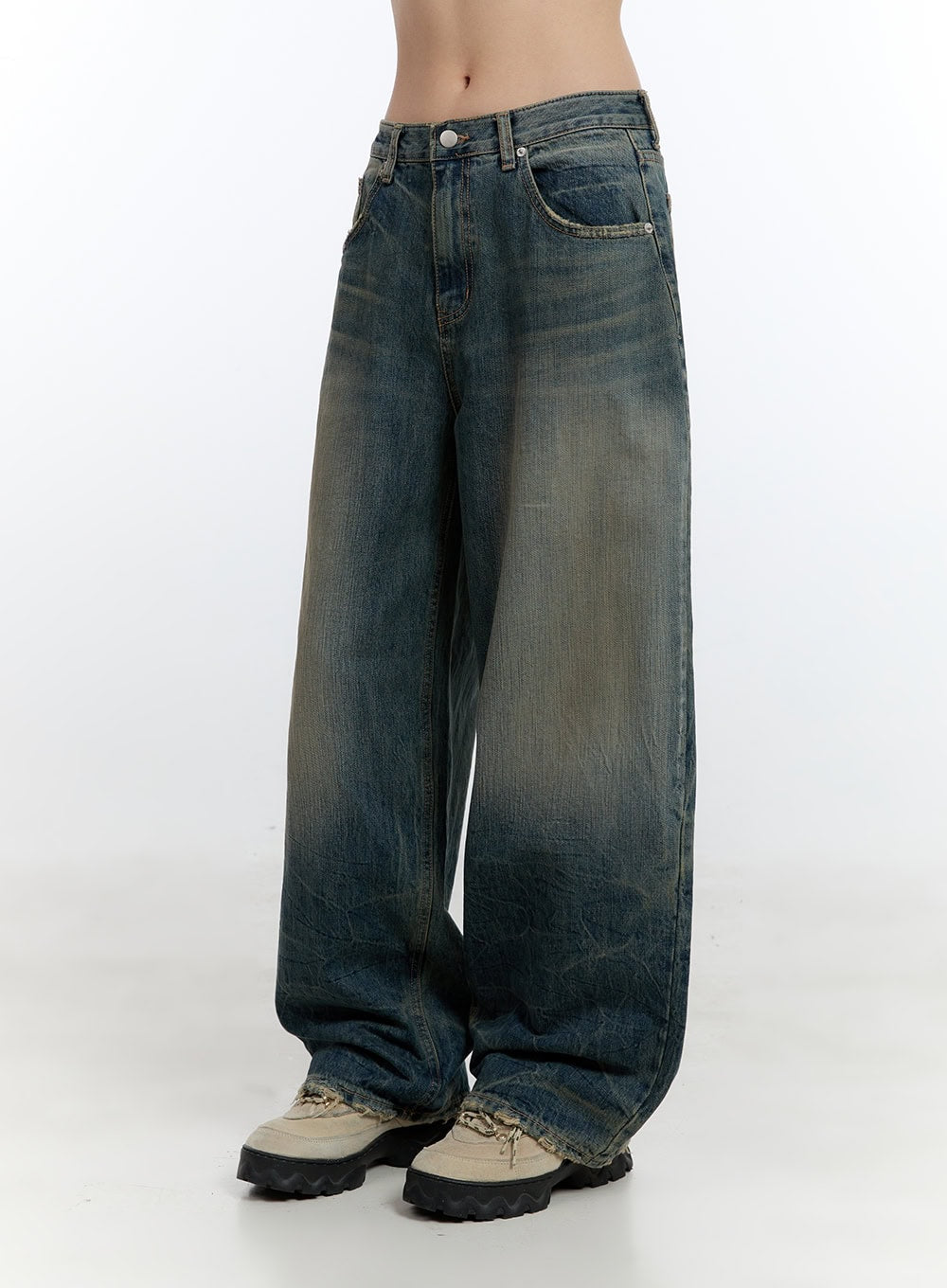 Danielle Vintage Washed Baggy Jeans CJ522 in blue, side-front close-up on model, highlighting low-rise waist, deep side pocket, yellow-tinted vintage wash, and raw frayed hem over sneakers.