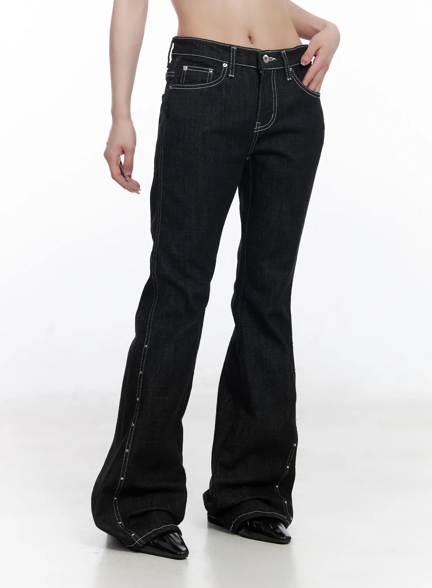 Dahy Stylish High-Waisted Bootcut Jeans CJ526 in black, angled front close-up on model, highlighting high waist, contrast topstitching on pockets, and stud-lined side seam flaring at the hem.