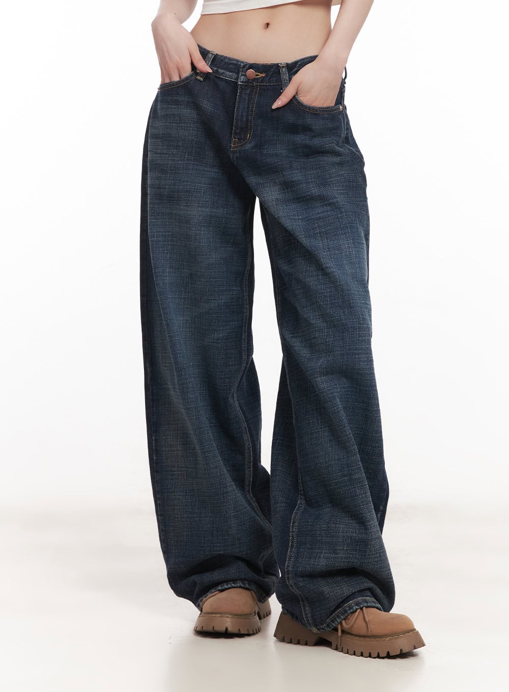 Annie Washed Wide-Leg Jeans CM518 in dark blue, front mid-body shot on model, low-rise wide-leg washed denim with hands in pockets, floor-grazing hem, paired with chunky boots.
