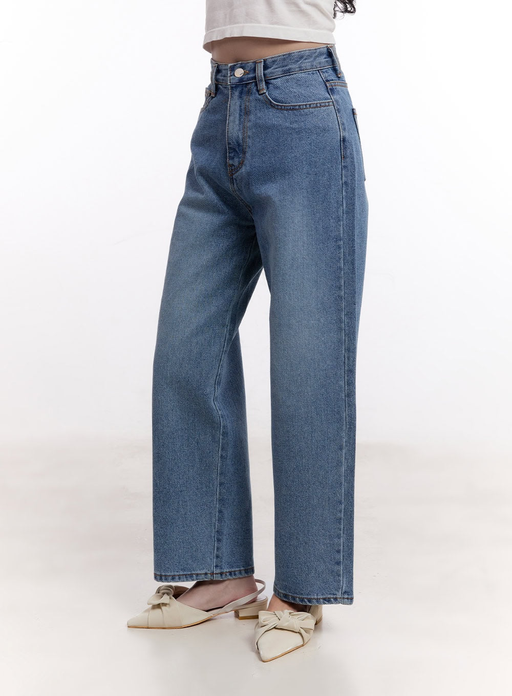 Jamie Comfy Straight-Fit Jeans CM526 in mid-blue wash, front side close-up on model, high-rise button closure with coin pocket, straight-leg washed denim, paired with bow slingback mules.