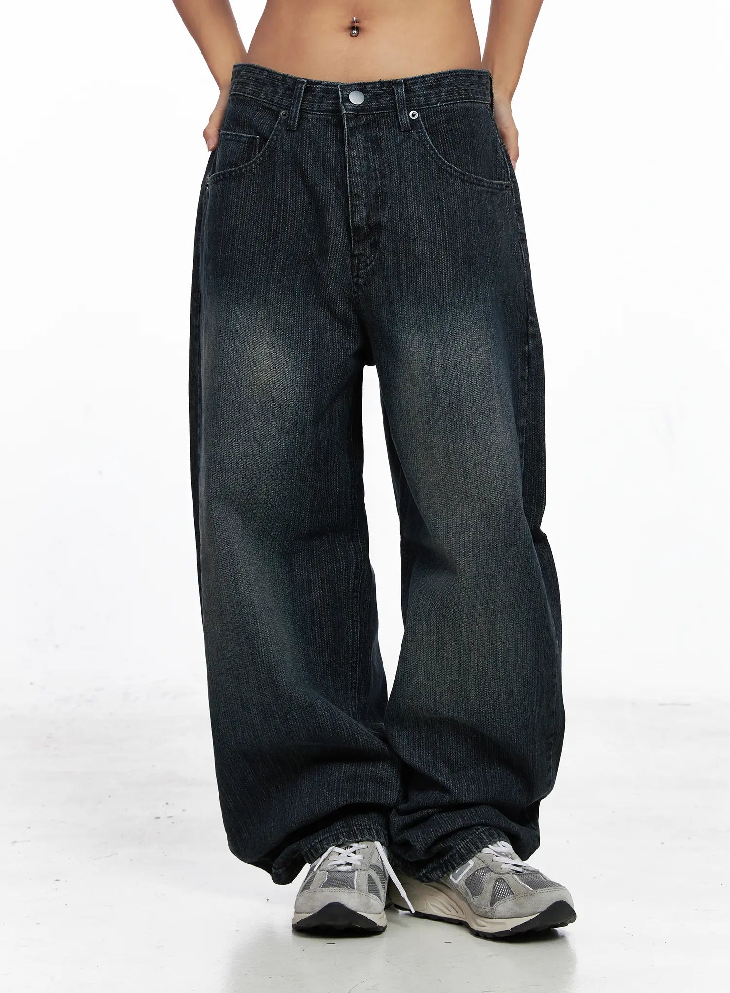 Aspyn Wide-Leg Washed Corduroy Jeans CO510 in dark blue, front mid-shot on model, hands in pockets, wide-leg corduroy silhouette with heavy washed fading, hem pooling at sneakers.