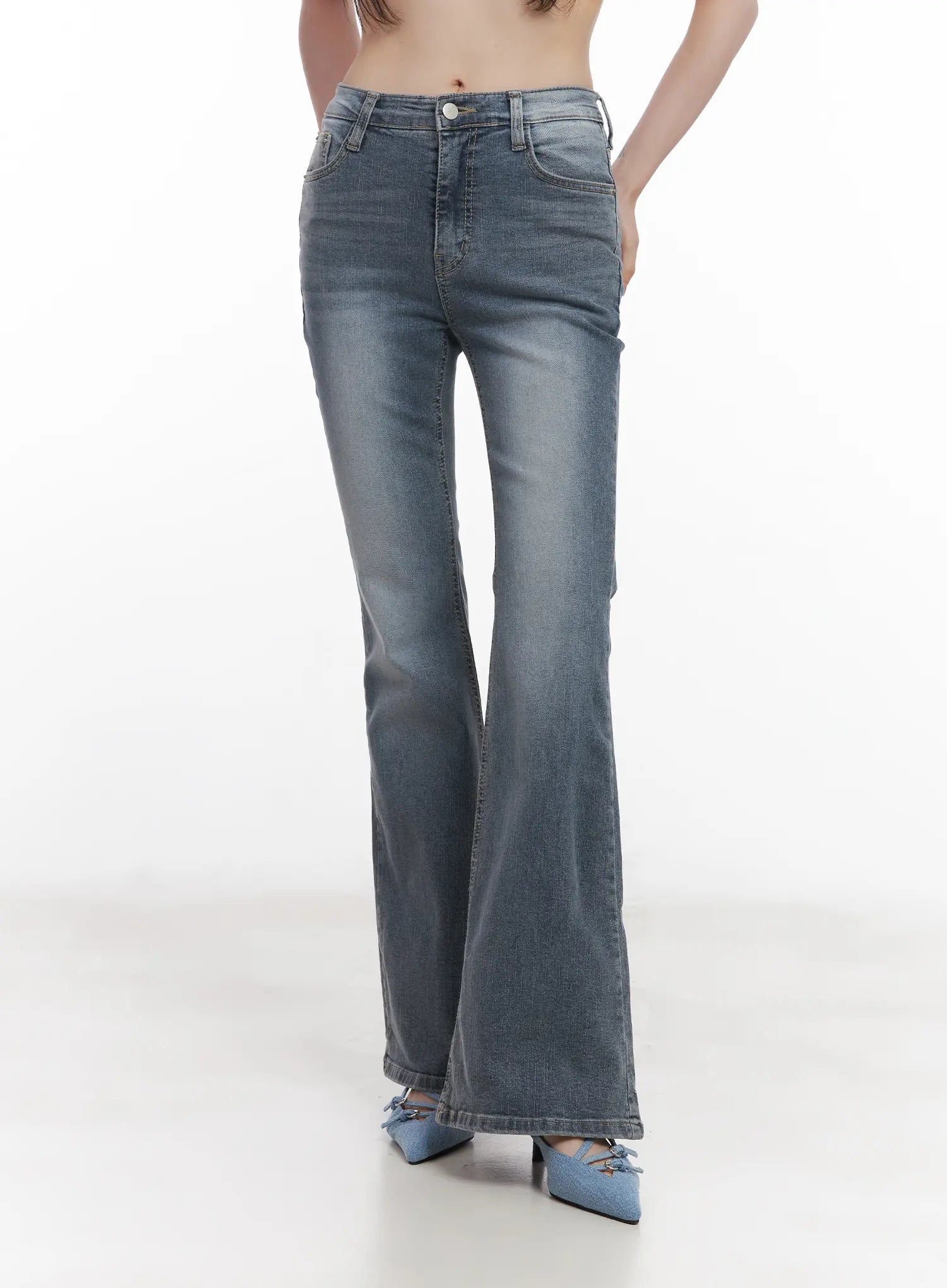 Soyeon Flared Jeans with Hip Pads CU520 in dark gray, front mid-shot on model, washed slim denim with subtle bootcut flare, hand in pocket pose, paired with blue bow mules.