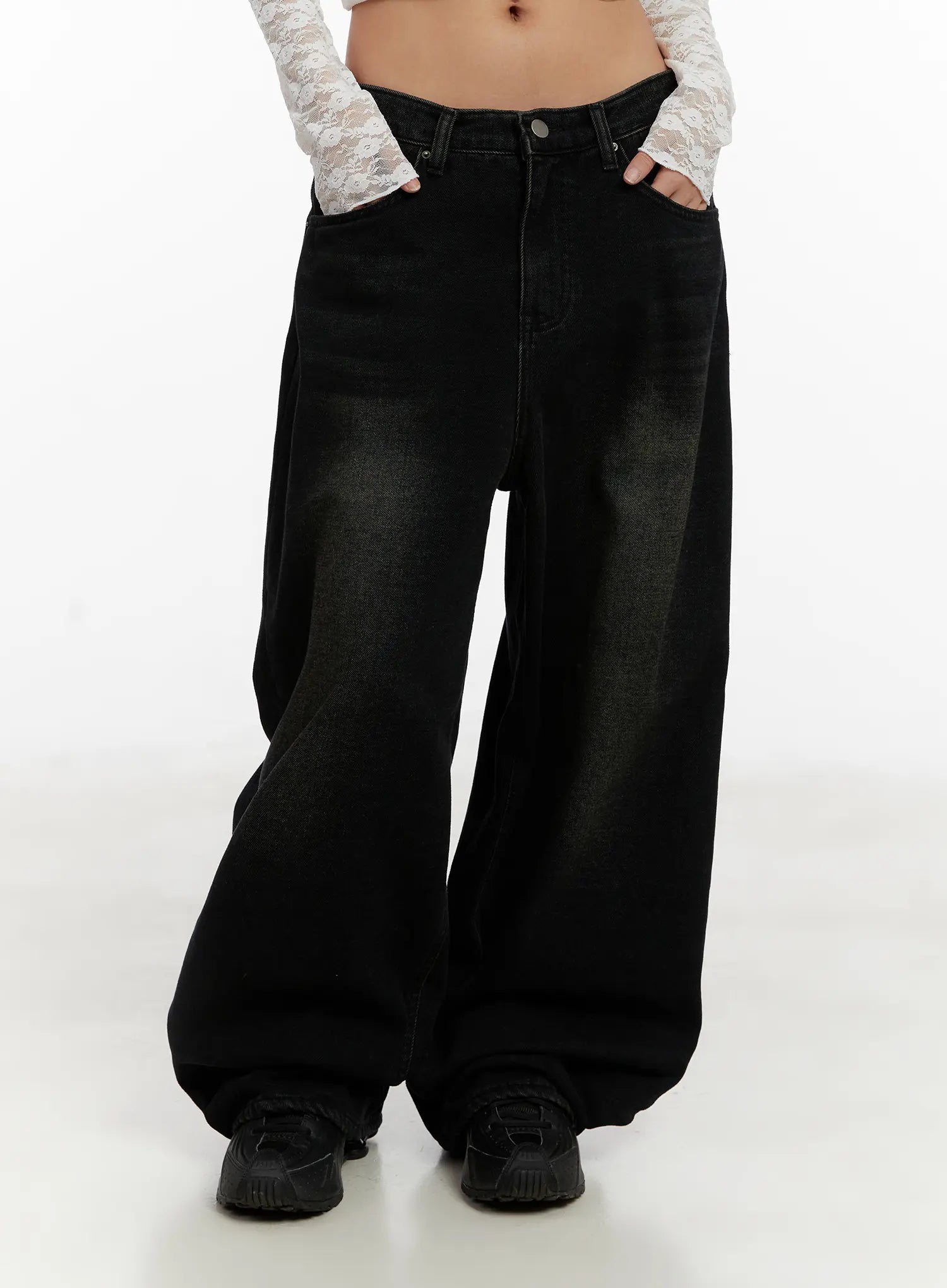 Myla Dark Wash Wide-Leg Jeans CD512 in dark black wash, front lower-body shot on model, wide-leg hem pooling over chunky sneakers, dark washed cotton with olive-toned fading at thighs.
