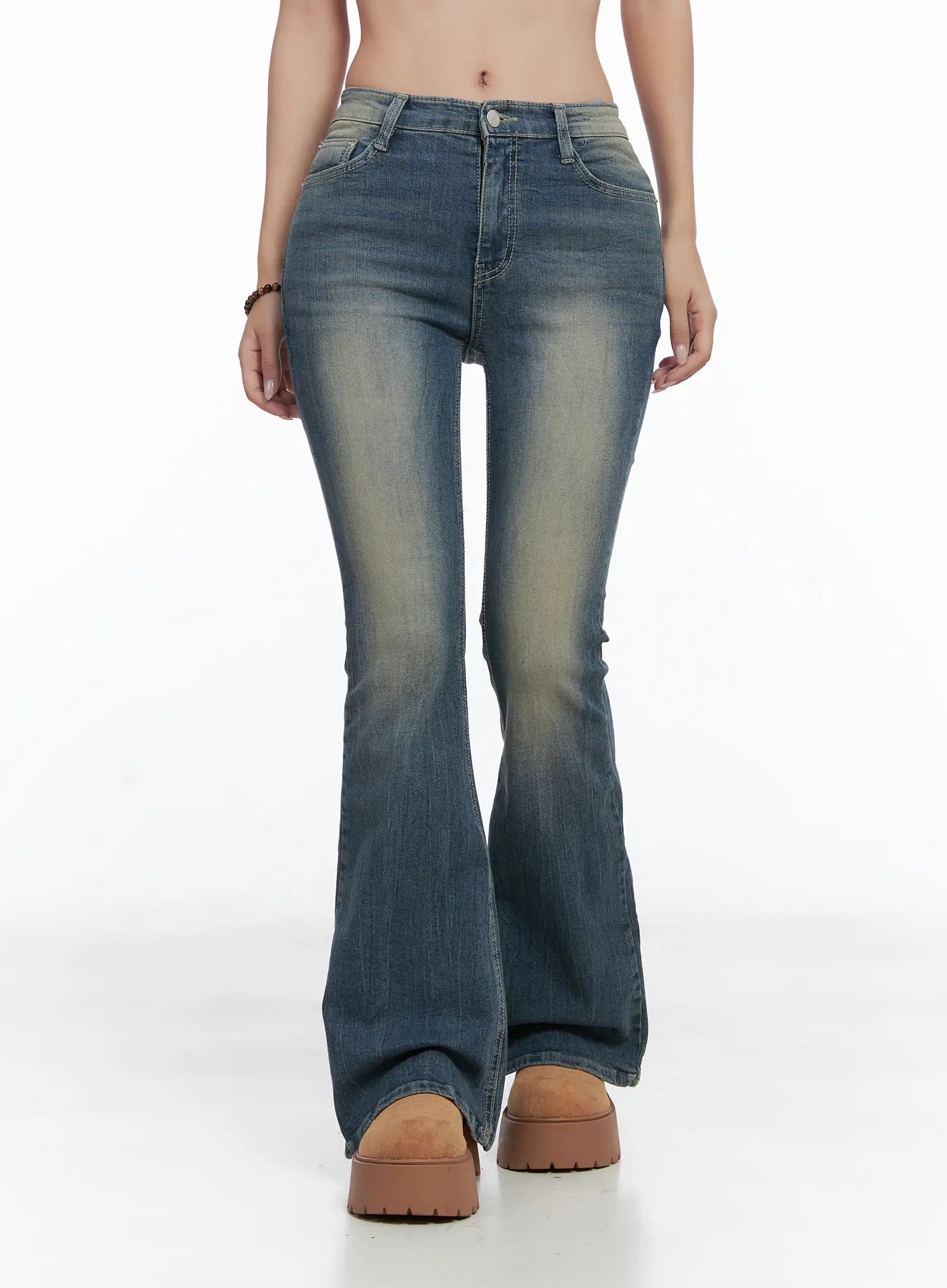 Sloan Vintage Hip Pad Flare Jeans CS502 in dark blue, front walking-angle shot on model, flare hem spreading at floor level, washed fading on thighs, slim fit through hips.
