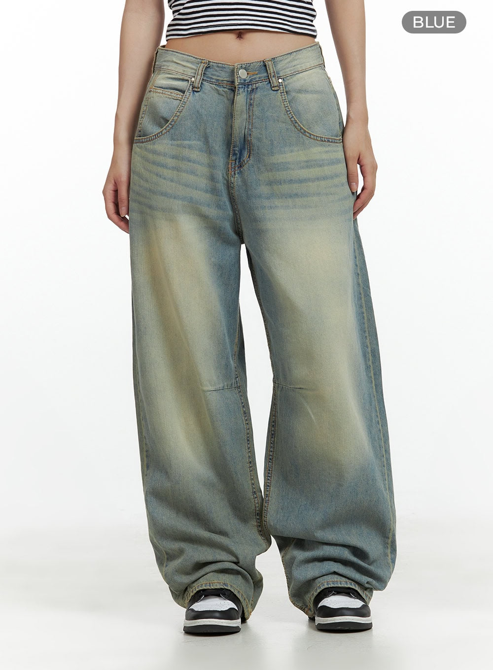 Relaxed Wide-Leg Jeans CU420 in blue, front full-length product shot on model, washed cotton denim with yellow-toned fading and whisker detail, low-rise wide fit with stacked hem and sneakers.
