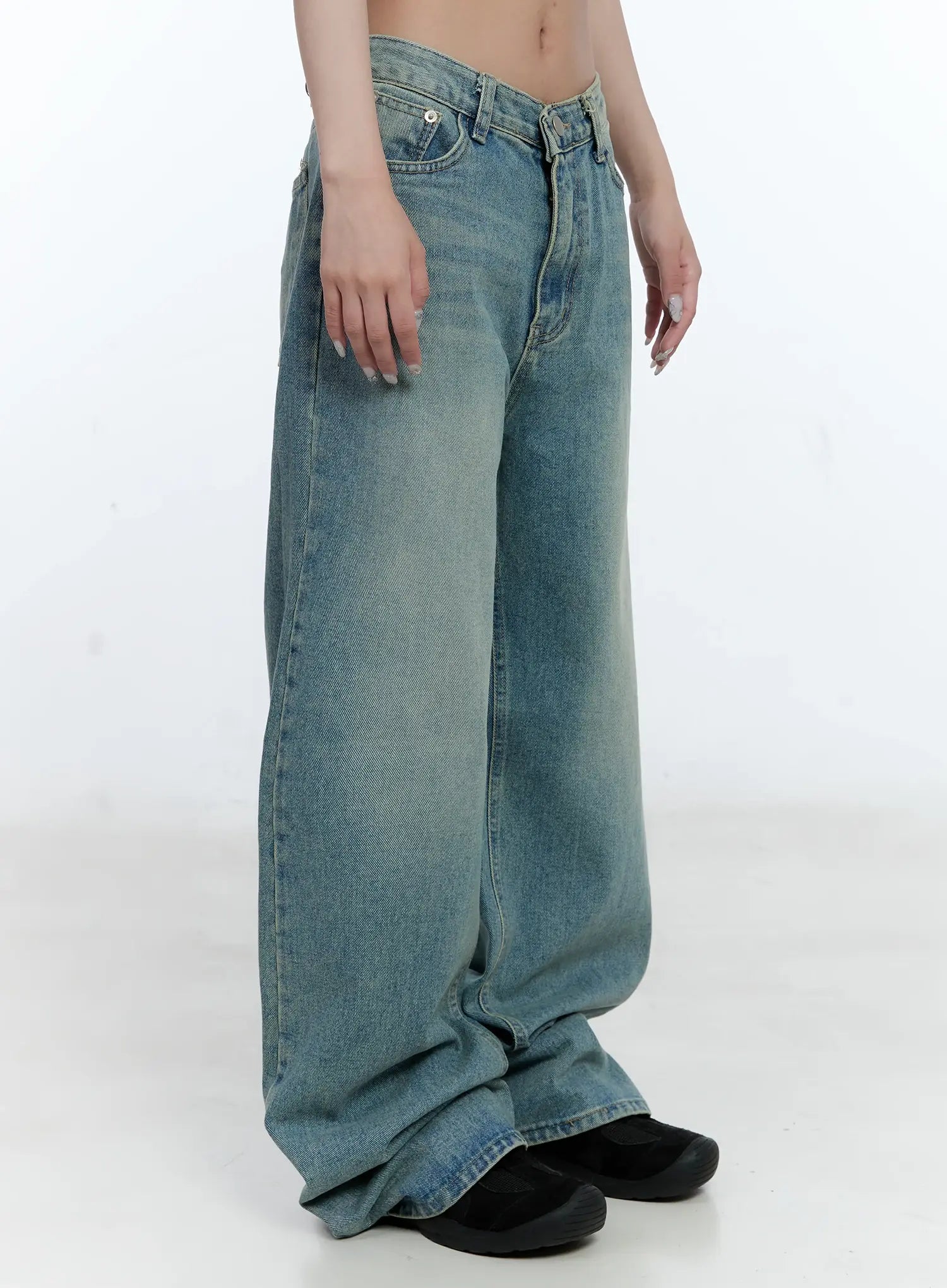Haeun Wide-Leg Denim Jeans CG501 in blue, side close-up from waist to hem on model, low-rise V-cut waistband and voluminous washed denim leg with bunched floor hem.
