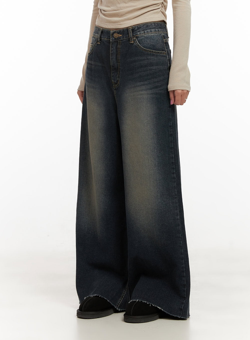 Tasha Low Waist Washed Wide Leg Jeans CD410 in dark blue, side close-up on model, low-waist cotton denim with vintage yellow-tinted wash, exaggerated wide leg, frayed raw hem, showing waistband hardware.