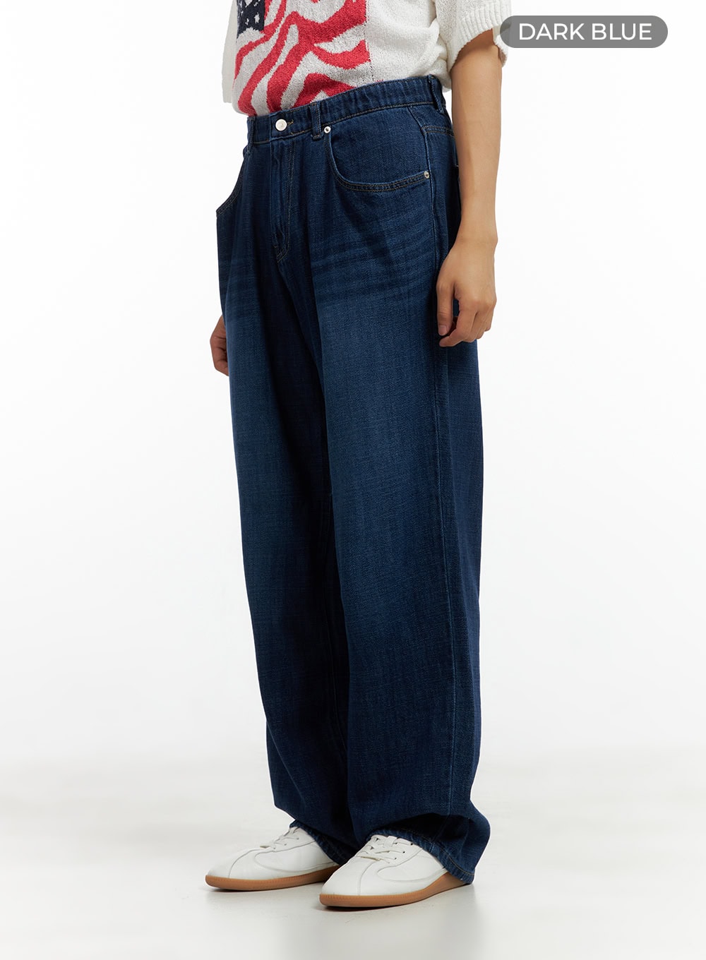 Men's Washed Cotton Denim Jeans CL429 in dark blue, color-swatch side view on model, wide-leg washed denim, elastic waist, relaxed fit, paired with white flag-print knit and sneakers.