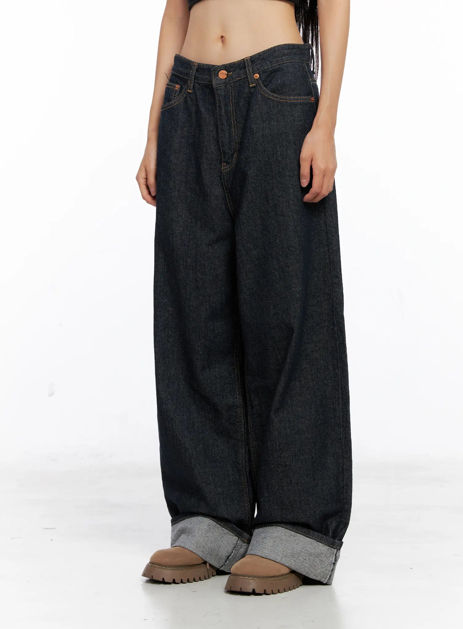 Oakley Cuffed Wide-Leg Jeans CS511 in dark blue, front three-quarter shot on model, low-rise waist, loose cotton wide-leg fall, grey contrast roll-up cuff at hem, copper rivet hardware.