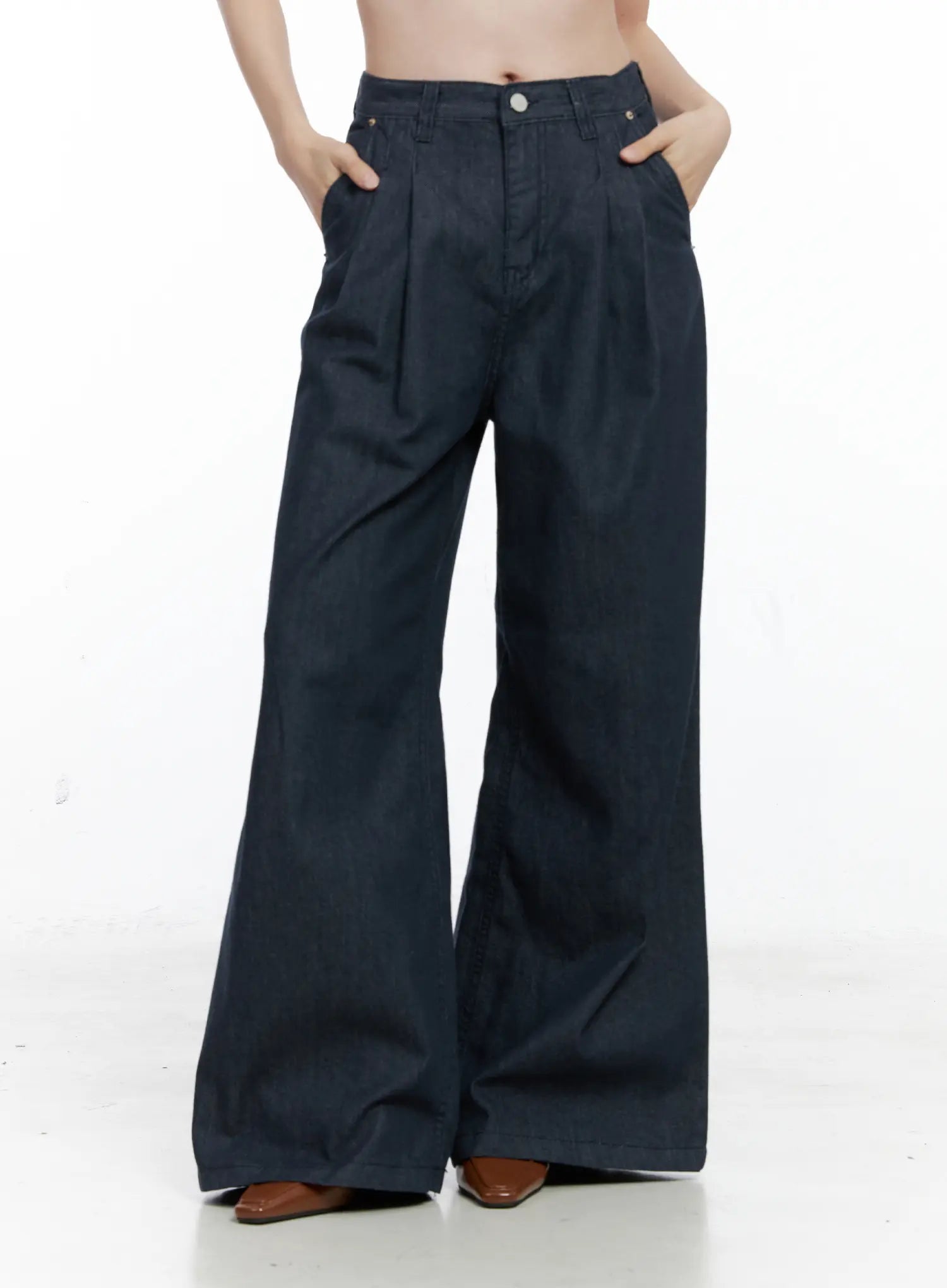 Lena Pintuck Baggy Jeans CO503 in dark blue, front mid-body shot on model with hands in pockets, highlighting pintuck pleats, wide-fit waistband, and long bootcut hem in cotton denim.