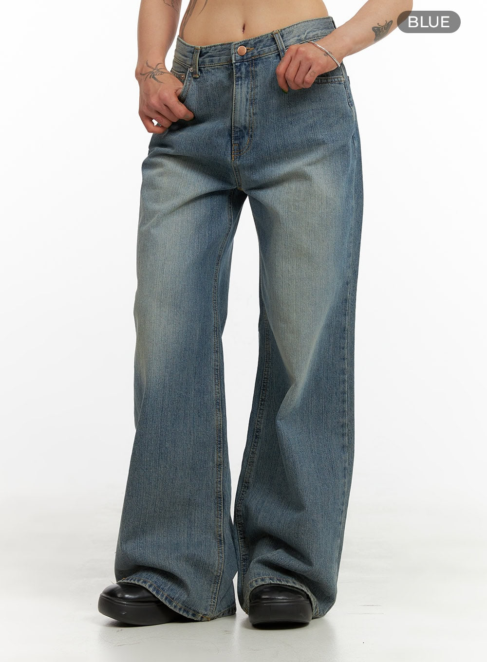 Wide Washed Denim Jeans CY429 in blue, front mid-shot on model gripping waistband, showing low-rise fit, washed fading on thighs, five-pocket wide-leg cotton denim, color variant label visible.