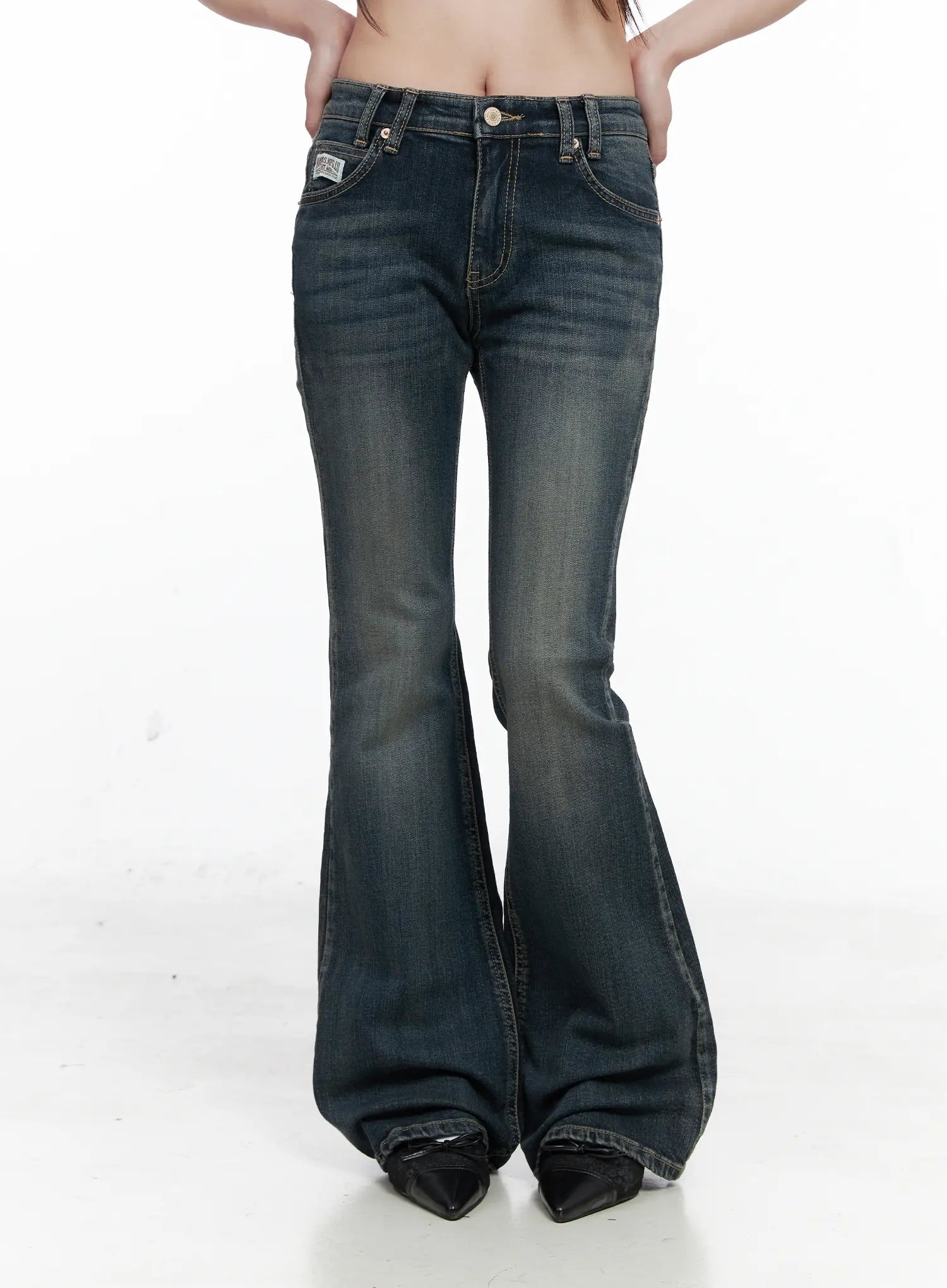 Rosé Washed Bootcut Jeans CO520 in dark blue, front product-style shot on model, low-rise waistband with double belt loops, washed flare leg full length, black pointed boots.
