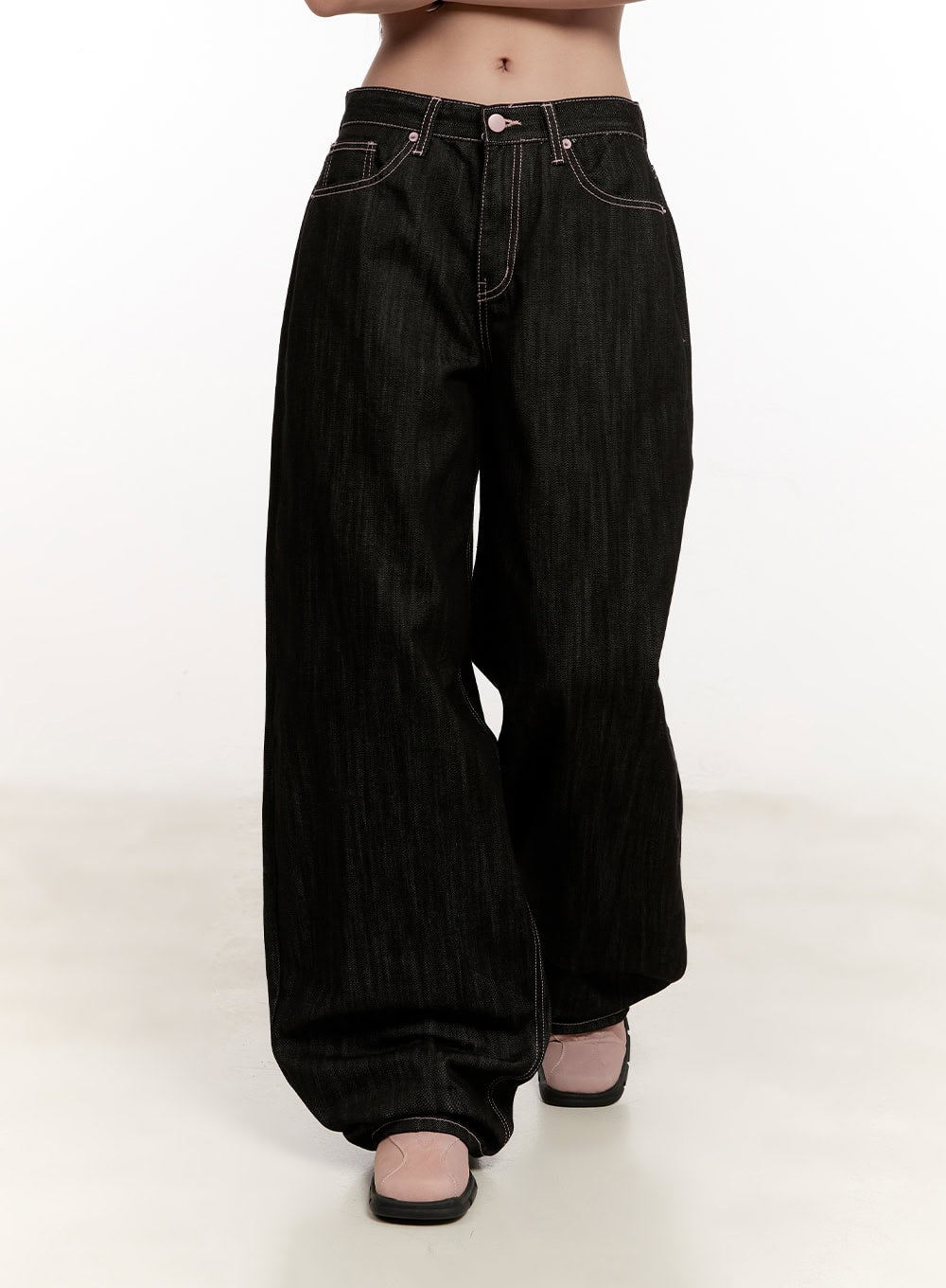 Trinity Stitched Baggy Jeans CM510 in black, front mid-shot on model, low-rise waistband with pink button and contrast stitching, voluminous wide-fit cotton denim leg.