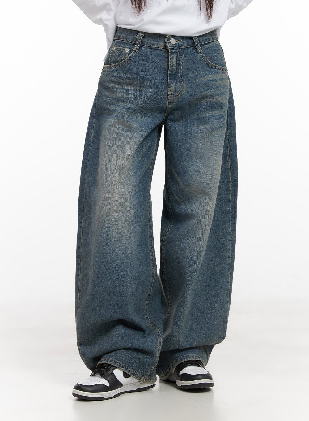 Mikaela Comfy Baggy Jeans CD411 in blue, front mid-shot from waist down on model, washed cotton denim with 5-pocket construction, voluminous baggy leg draping over sneakers.