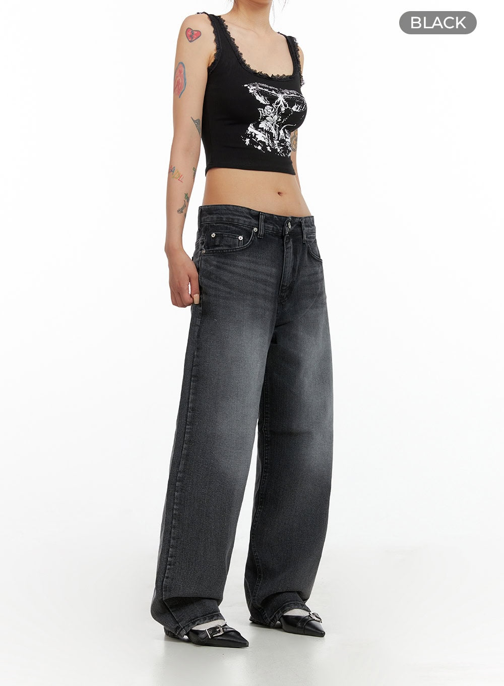 Low Rise Wide Leg Jeans CL415 in black, angled three-quarter front view on model, low-rise washed denim, wide leg fit, styled with graphic crop tank and buckle mules.