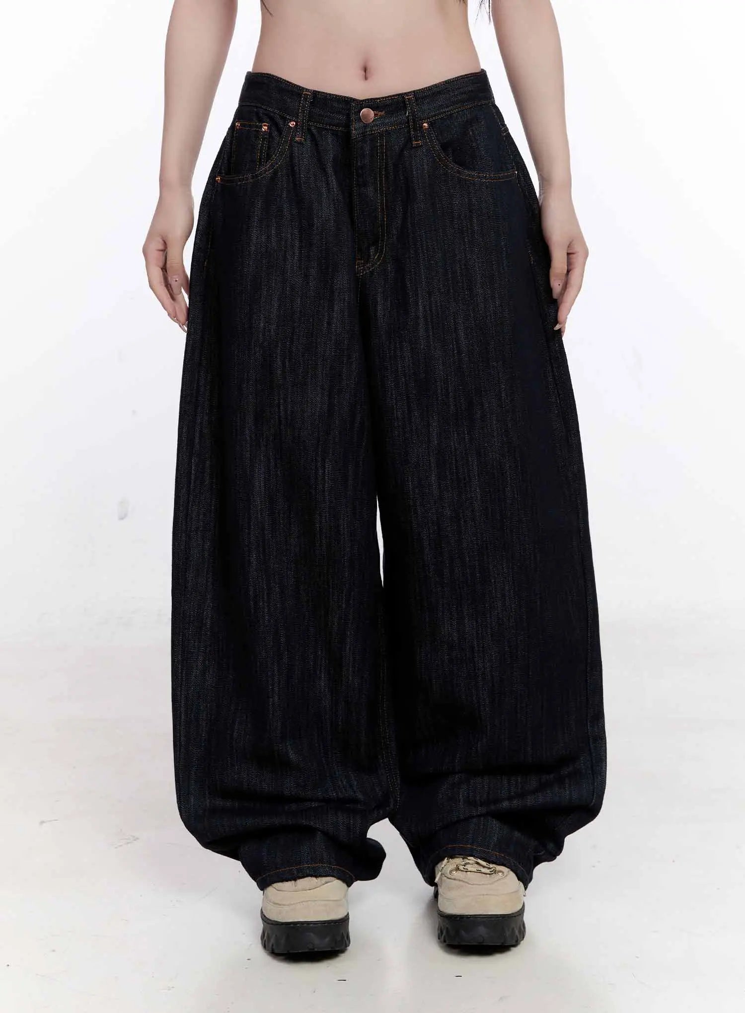 Haewon Dark Washed Baggy Jeans CS530 in dark blue, front full-length view on model, low-rise waist with five-pocket construction, ultra-baggy ballooned leg gathered at ankle over chunky sneakers.