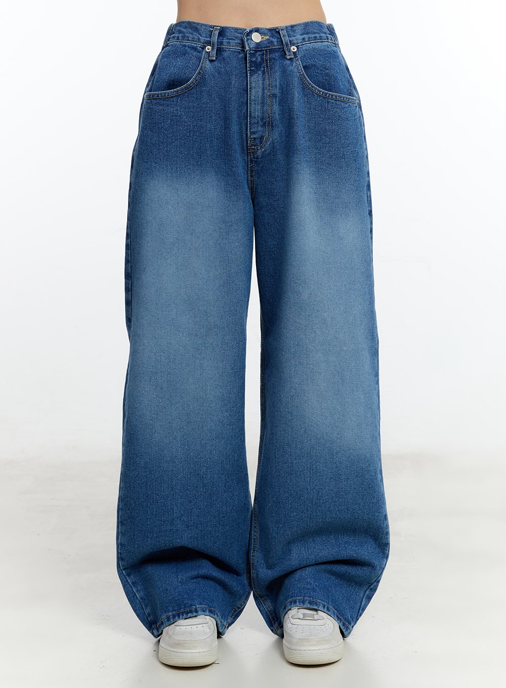 Eugene Adjustable Cinched-Back Wide-Leg Jeans CM521 in dark blue, front product-focused shot on model, washed denim with button closure, front pockets, wide-leg drape pooling at hem over white sneakers.