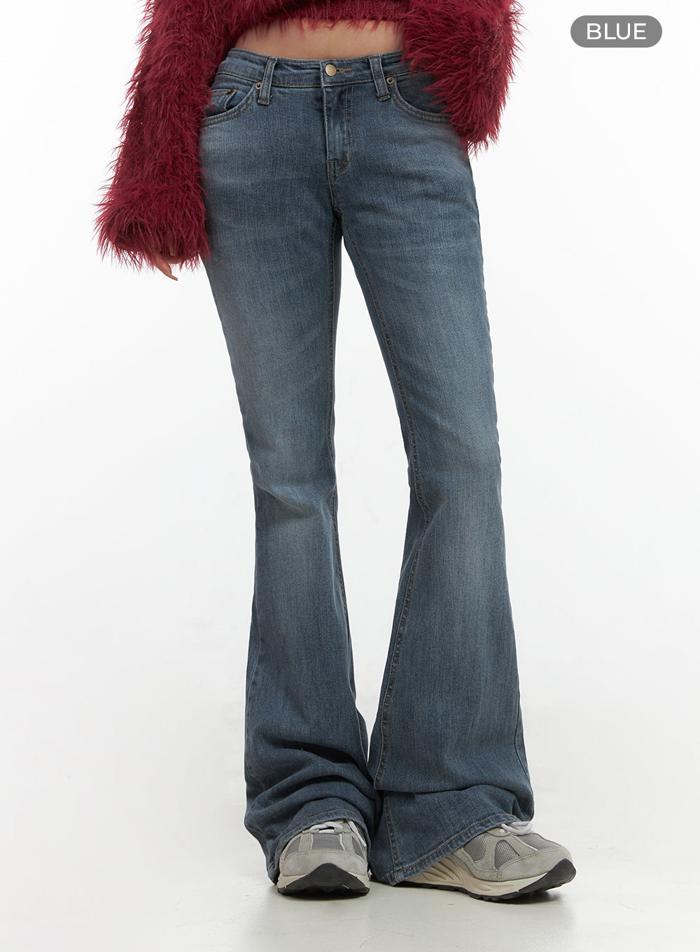 Liv Washed Denim Low Waist Bootcut Jeans CO414 in blue, front lower-body shot on model, low waist button closure, slim-fit washed denim flaring at hem, paired with red shaggy crop top and sneakers.