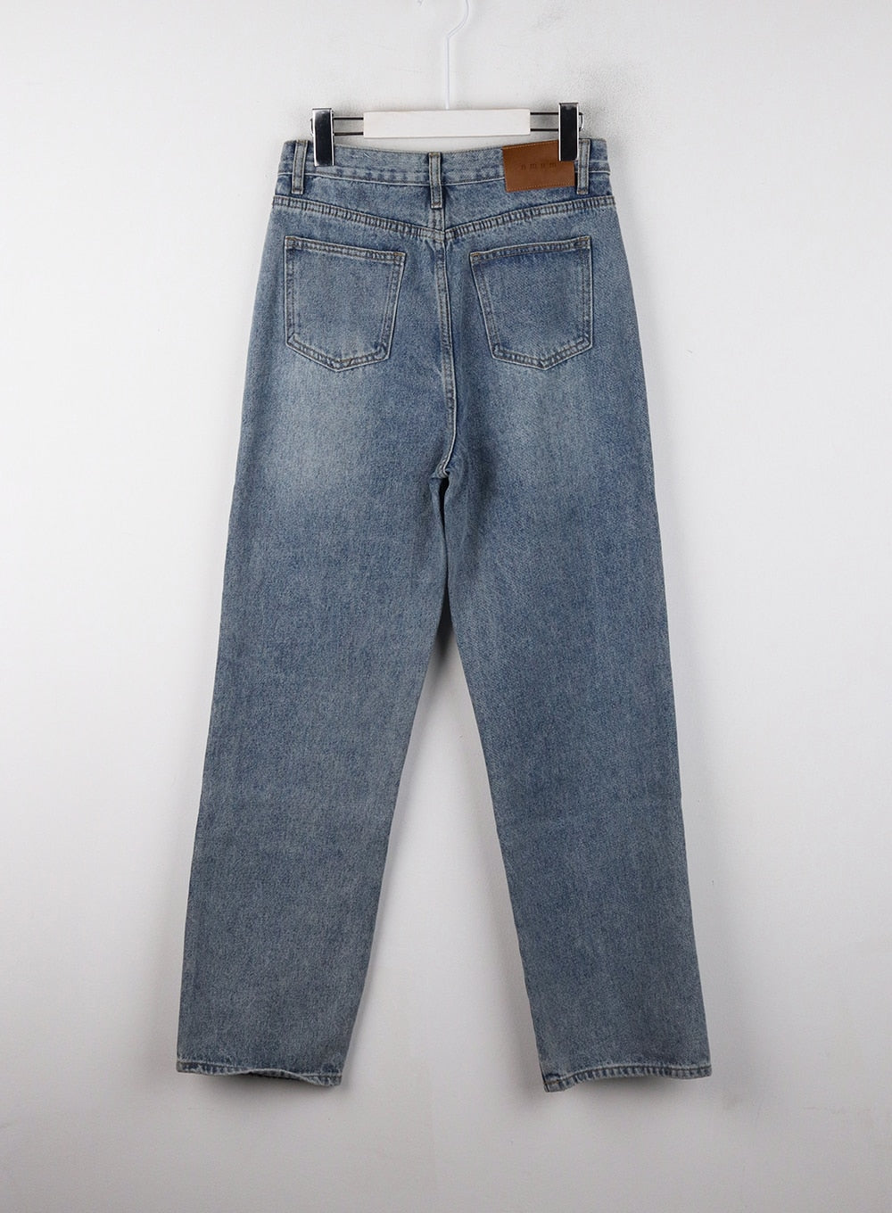 Washed Straight Wide Denim OJ405 in blue, flat back product shot on hanger, dual back pockets with leather brand patch at waistband, washed straight wide leg.