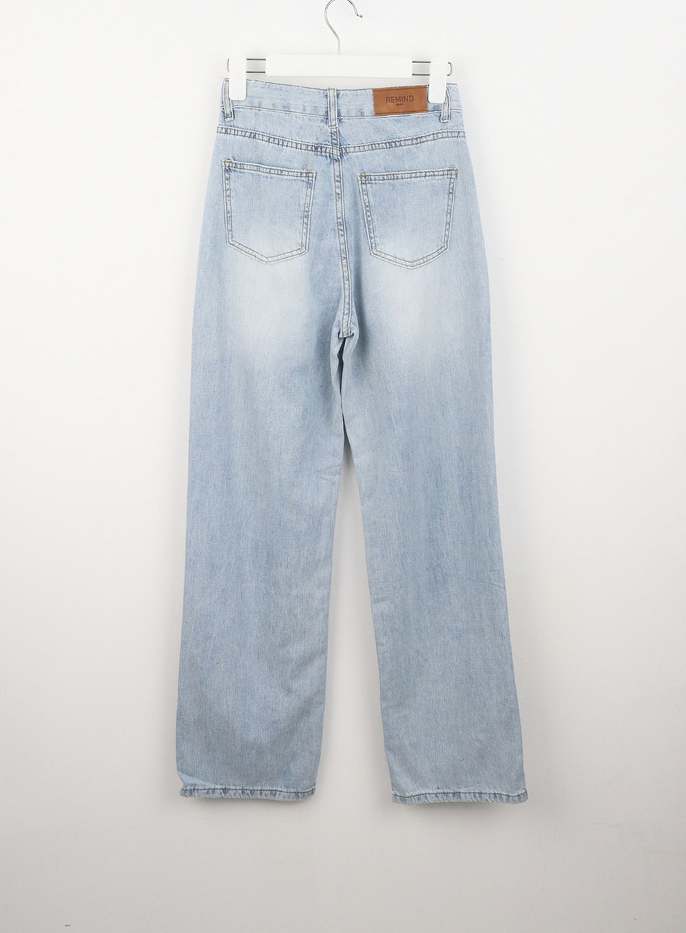 Wide Straight Leg Jeans OL304 in light blue, flat hanger back shot, dual patch pockets with topstitching, leather brand tab at waist, faded wide-leg cotton denim.