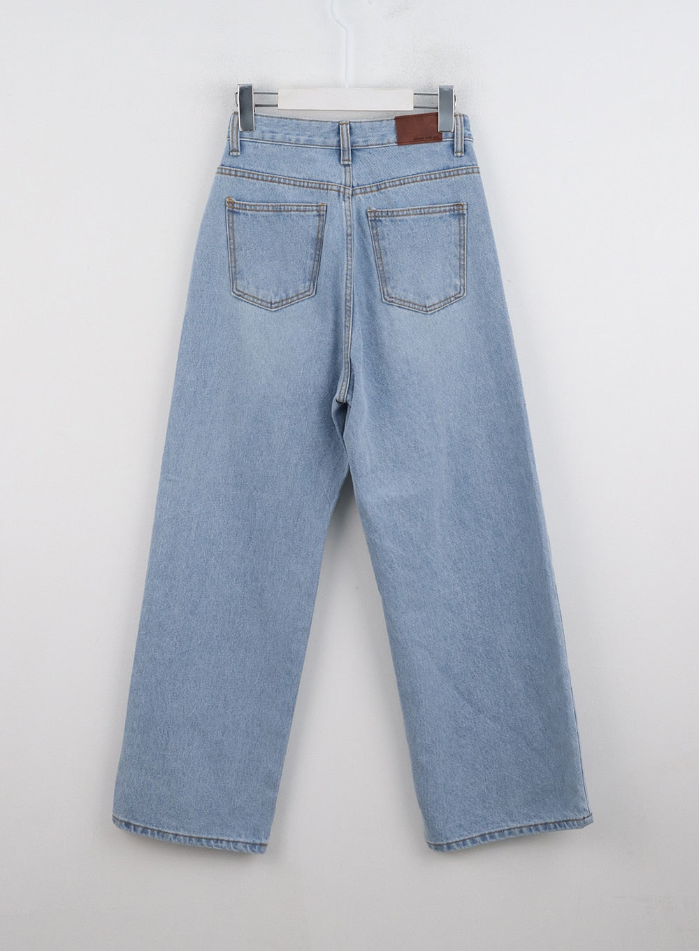Light Washed Straight Jeans ON329 in light blue, flat hanger back product shot, dual patch pockets with contrast stitching and brown leather waistband label.