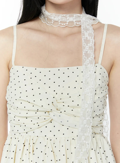 LEWKIN Quentin Race Scarf IU503 in white, close-up neck detail on model, sheer polyester lace with scalloped floral edge worn as choker, draped over polka-dot dress.