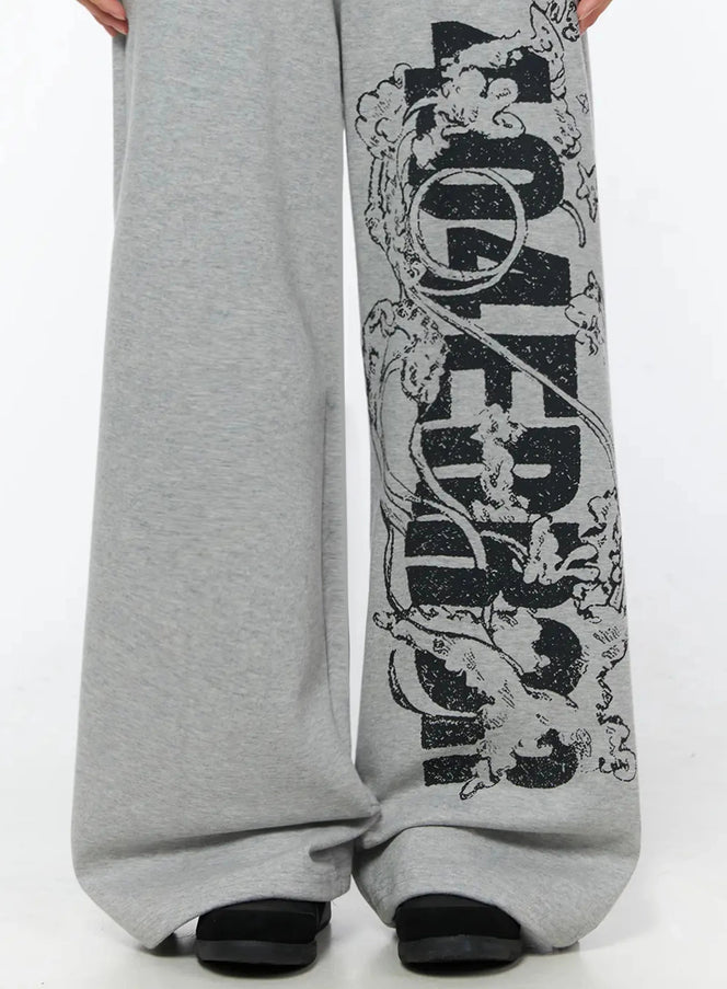 404 Error Graphic Sweatpants IL516 Gray close-up detail shot showing distressed black graphic lettering and angel illustration on wide leg panel
