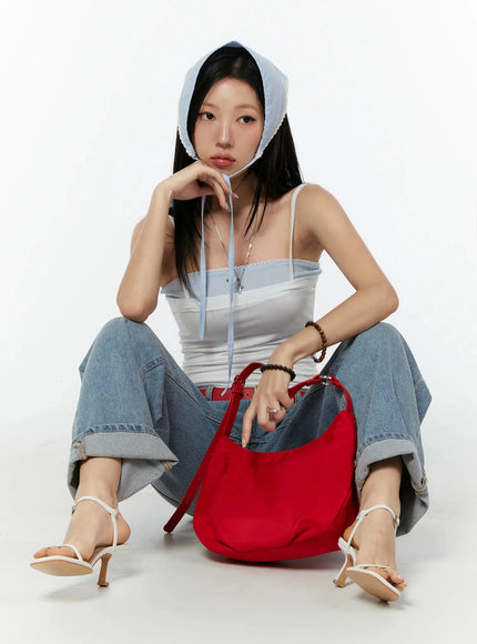 Adeya Cuffed Straight Jeans IU524 Blue seated lifestyle shot on model wearing blue headscarf and white cami, holding red bag, showing cuffed hem and wide-leg silhouette