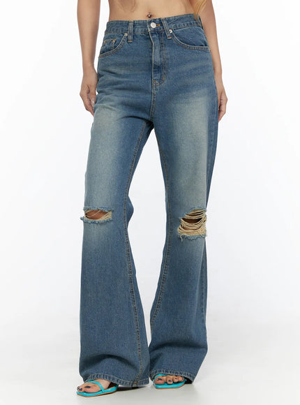 LEWKIN Ahmad Distressed Flared Jeans CL528 Blue front close-up on model cropped at waist showing ripped knee details and flared hem with teal sandals size S