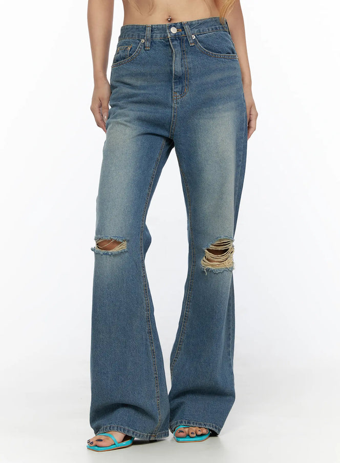 LEWKIN Ahmad Distressed Flared Jeans CL528 Blue front close-up on model cropped at waist showing ripped knee details and flared hem with teal sandals size S