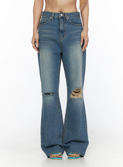 Ahmad Distressed Flared Jeans CL528 Blue front full-length shot on model showing high waist button closure dual knee rips flared hem and teal sandals