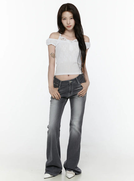 Alira Dark Wash Bootcut Jeans IL522 Gray full-body front shot on model styled with white off-shoulder top hands on hips flared bootcut silhouette white mules