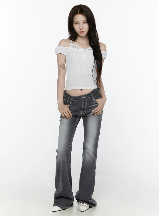 Alira Dark Wash Bootcut Jeans IL522 Gray full-body front shot on model styled with white off-shoulder top hands on hips flared bootcut silhouette white mules