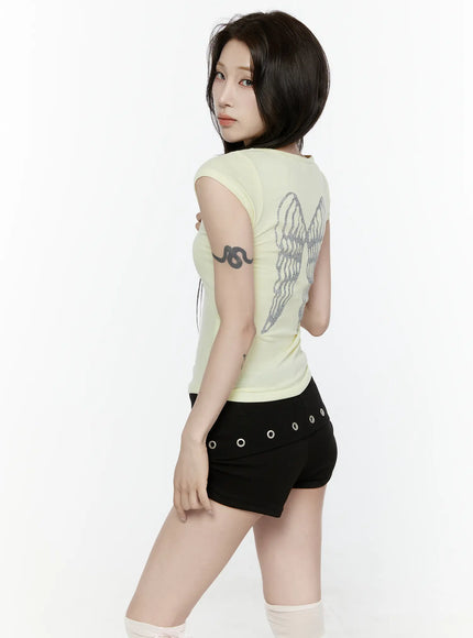 Angel Slim T-Shirt IL522 Light yellow back three-quarter side view model glancing over shoulder glitter angel wings graphic visible on slim ribbed tee