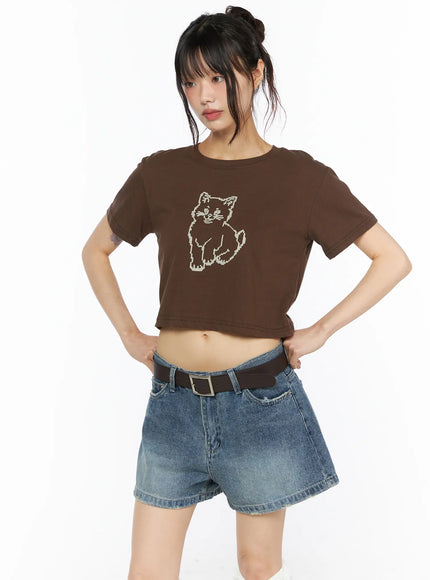 LEWKIN Animal Graphic Crop Tee CU530 Brown front view on model hands on hips wearing denim shorts and brown belt pixel cat graphic