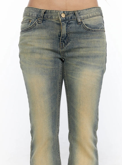 Archie Deep Tint Wash Capri Jeans CL528 Blue close-up detail shot on model showing low-rise waistband gold button five-pocket construction and yellow-tinted denim texture